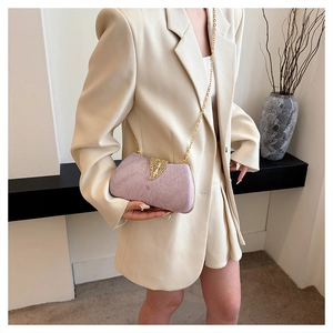 Detail of lavender star box clutch with gold leaf clasp and chain on a stylish model