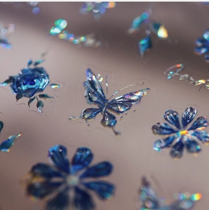 Macro shot of 3D laser blue butterfly and flower nail stickers with relief texture