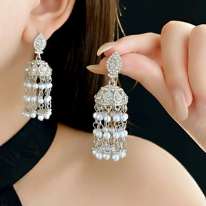 Macro view of vintage silver tassel earrings with white pearls and clear rhinestones