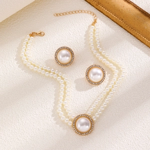 Detail of elegant double-layer pearl necklace set with matching stud earrings and gold finish