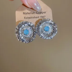 Vintage silver sunflower stud earrings with light blue gemstone and textured petals