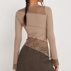 Detail of khaki long sleeve shirt featuring intricate lace patchwork and irregular hem