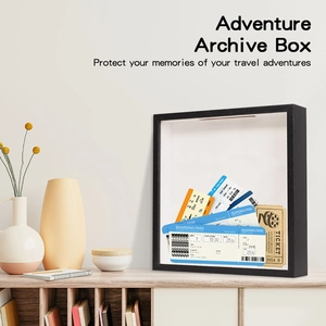 Adventure Archive Box ticket shadow box placed on a wooden desk with home decor items