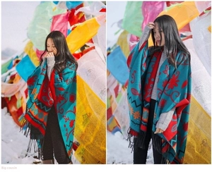 Close-up of ethnic style cashmere shawl with teal floral patterns and black tassels