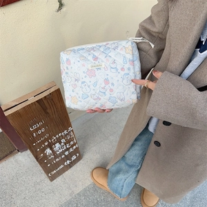 Détail d'une trousse de maquillage en coton matelassé avec motifs colorés et fermeture