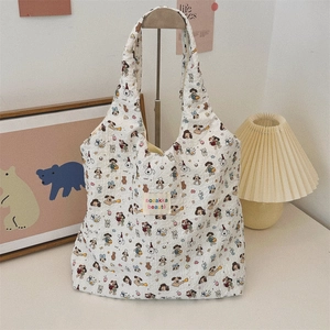 Detail of printed canvas tote bag with colorful cartoon illustrations and logo label
