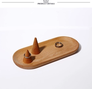 Detailed view of oval solid wood jewelry tray with two conical ring stands for display