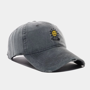 Detailed view of sun embroidery and distressed brim on washed cotton baseball cap