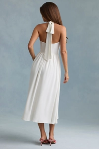 Detail of elegant white halter neck dress featuring an open back and tie-up neck design