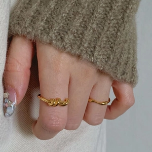Detail view of 925 sterling silver spiral irregular rings in gold finish worn by a model