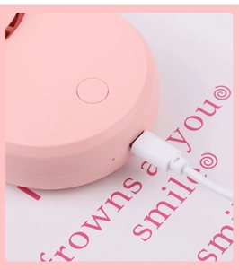 Detail of the pink lash dryer Micro-USB port and charging cable connection