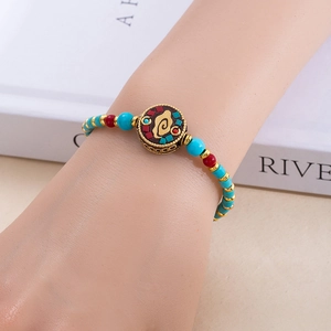 Détail d'un bracelet de perles bohème avec perles turquoise et pendentif totem vintage