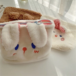 Close-up of cute plush bunny storage bags with detailed embroidery and metal zipper