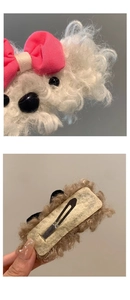 Detail view of plush puppy hair clip with pink bow and silver metal duckbill clip back