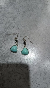 Detail of silver-tone bohemian heart earrings with turquoise stones and black teardrop beads
