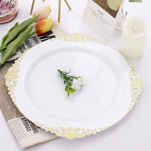 Detail of white round dinner plate with gold hollow pattern edge on elegant tabletop