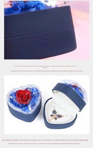 Macro shot of heart-shaped preserved flower jewelry box with elegant butterfly necklace
