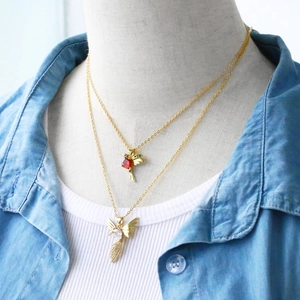 Detailed layered hummingbird necklace set with red and green stones on a model