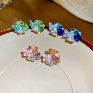 Macro shot of 18k gold plated butterfly stud earrings with colorful crystals and pearls
