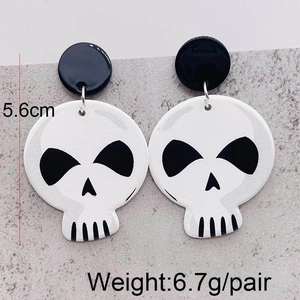 Makroaufnahme von Halloween-Totenkopf-Ohrringen mit Größen- und Gewichtsangaben