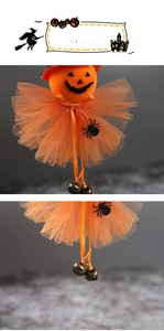 Detail of Halloween pumpkin doll with orange tulle skirt, spider decor and metal bells