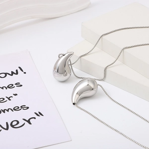 Polished silver hollow teardrop pendant necklaces with sleek snake chains on white background