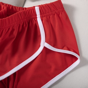 Nahaufnahme der roten Sporthose mit weißer Paspelierung und atmungsaktivem Gewebe