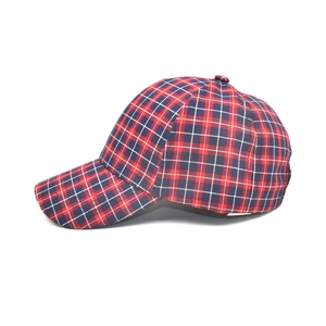 Side view of a red and blue plaid baseball cap showing fabric texture and curved brim
