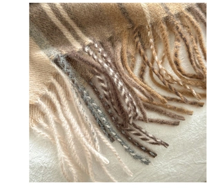 Close-up of fringe details and plush texture on classic plaid cashmere-like scarf