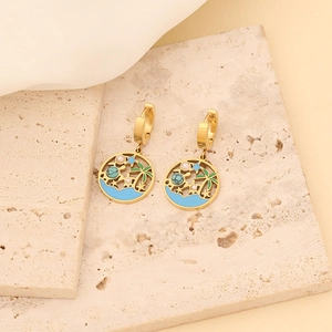 Detail of gold hoops featuring palm tree and sea pendants with turquoise and pearls