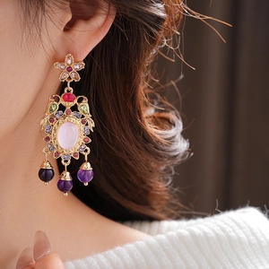 Close-up of vintage floral drop earrings with colorful crystals and gold detailing
