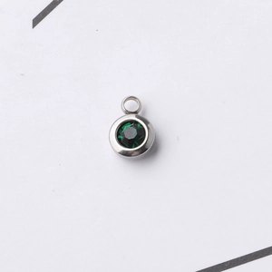 Close-up of a 6.5mm stainless steel pendant with a faceted green birthstone crystal