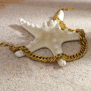 Detail of 18K gold-plated curb chain with lobster clasp on a beach starfish background