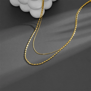Double-layered 18K gold plated necklace with delicate wheat and bead chains on grey background