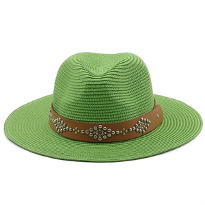 Detailed straw weave texture of a light green sun hat with a brown studded leather band