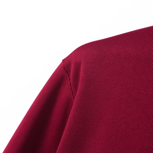 Detaillierte Nahaufnahme der weinroten Piqué-Stoffstruktur am Herren-Poloshirt