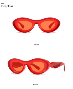 Close-up of retro wavy oval sunglasses with translucent red frames and tea lenses