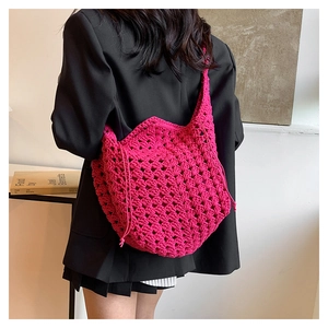 Dettaglio della borsa a tracolla fucsia all'uncinetto con design traforato e chiusura a lacci