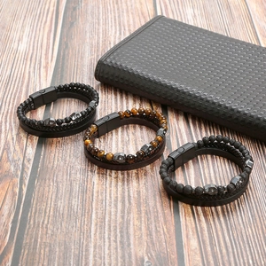 Close-up of leather and stone bead bracelets with metal skull charms on a wooden surface