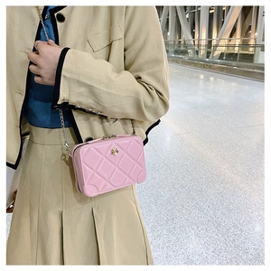 Close-up of pink jelly crossbody bag with diamond lattice pattern and gold flower buckle