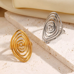 Detail of gold and silver swirl rings on stone texture with cream satin background