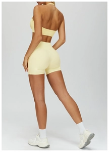 Detail view of the pale yellow high-waisted fitness shorts and halter sports bra back design