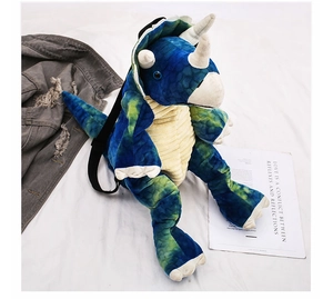 Close-up of triceratops plush backpack showing tie-dye fabric and corduroy texture details