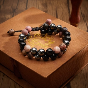 Détail d'un bracelet tissé double couche ajustable avec perles dans une boîte cadeau