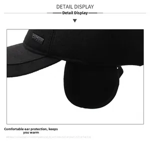 Close-up of black fleece baseball cap with ear flaps and metal CAPS logo detail