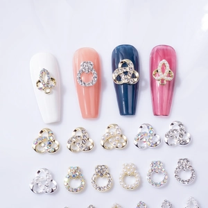 Bijoux d'ongles en alliage coeur évidé avec perles et strass aurora sur fond blanc