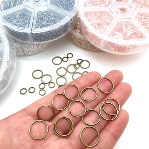 Variety of multicolor open jump rings in a plastic storage box for DIY jewelry making