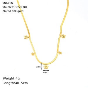 Macro detail of 18K gold plated stainless steel star pendants on a dainty chain necklace