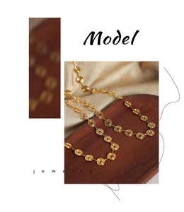 Detailed view of golden spiral geometric links on a titanium steel necklace jewelry set