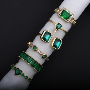Set of gold rings with emerald green zircon in heart, square, and teardrop shapes